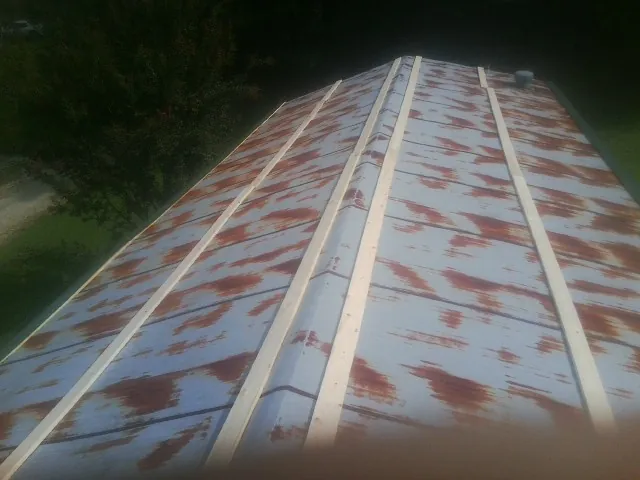 Rusted metal roof panels with new wood purlins before replacement — Storm Damage Roof Repair in Long Island by Roofing Brothers