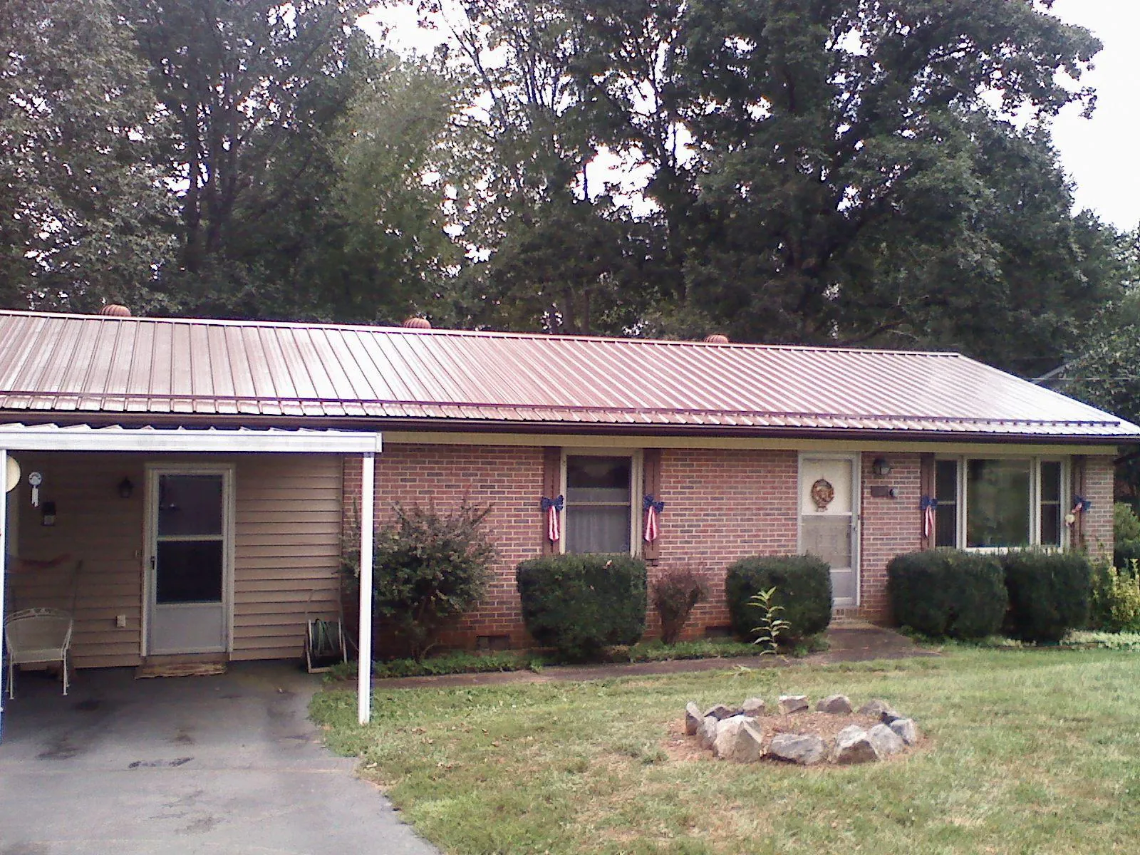 Bronze metal roof and carport on a brick ranch home — Roof Repair work by our crew in Long Island